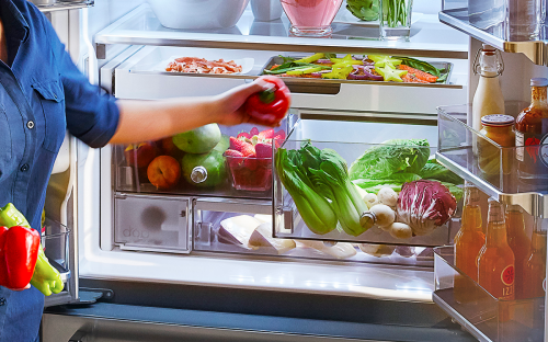 Woman taking food out of refrigerator 