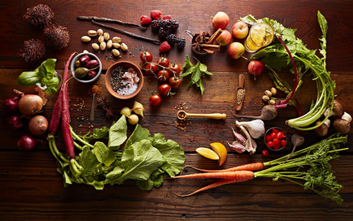 Various vegetables and herbs on wooden table