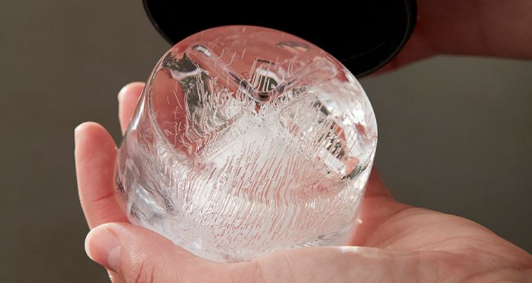 Someone holding a circular block of ice in their hand