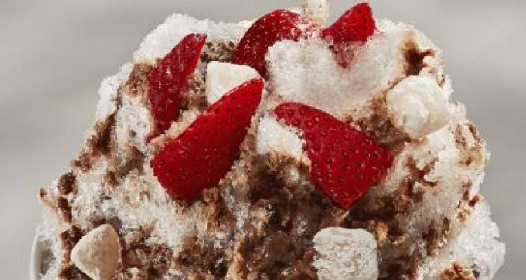  A bowl of bingsu topped with strawberries and other toppings.