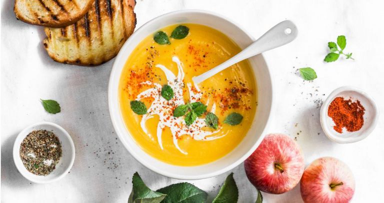 A bowl of winter squash soup with apples