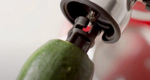 Gros plan sur l'accessoire coupe-feuilles de KitchenAid utilisé pour couper les courgettes.