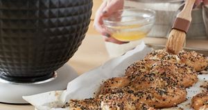 Using a pastry brush, the pretzel dough's surface is meticulously brushed with an egg wash.