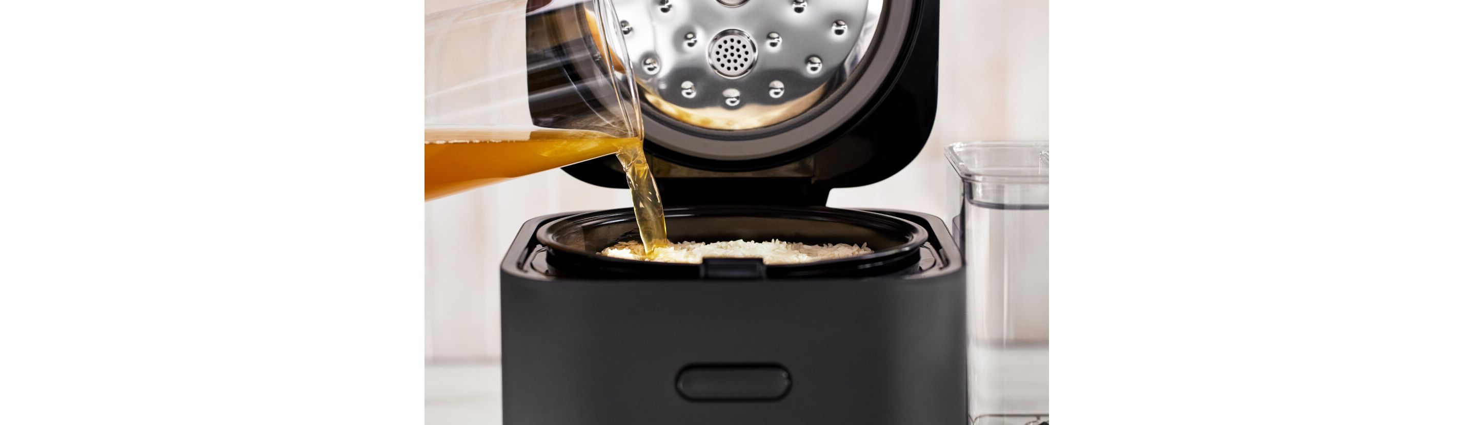 Broth being poured into the grain and rice cooker.